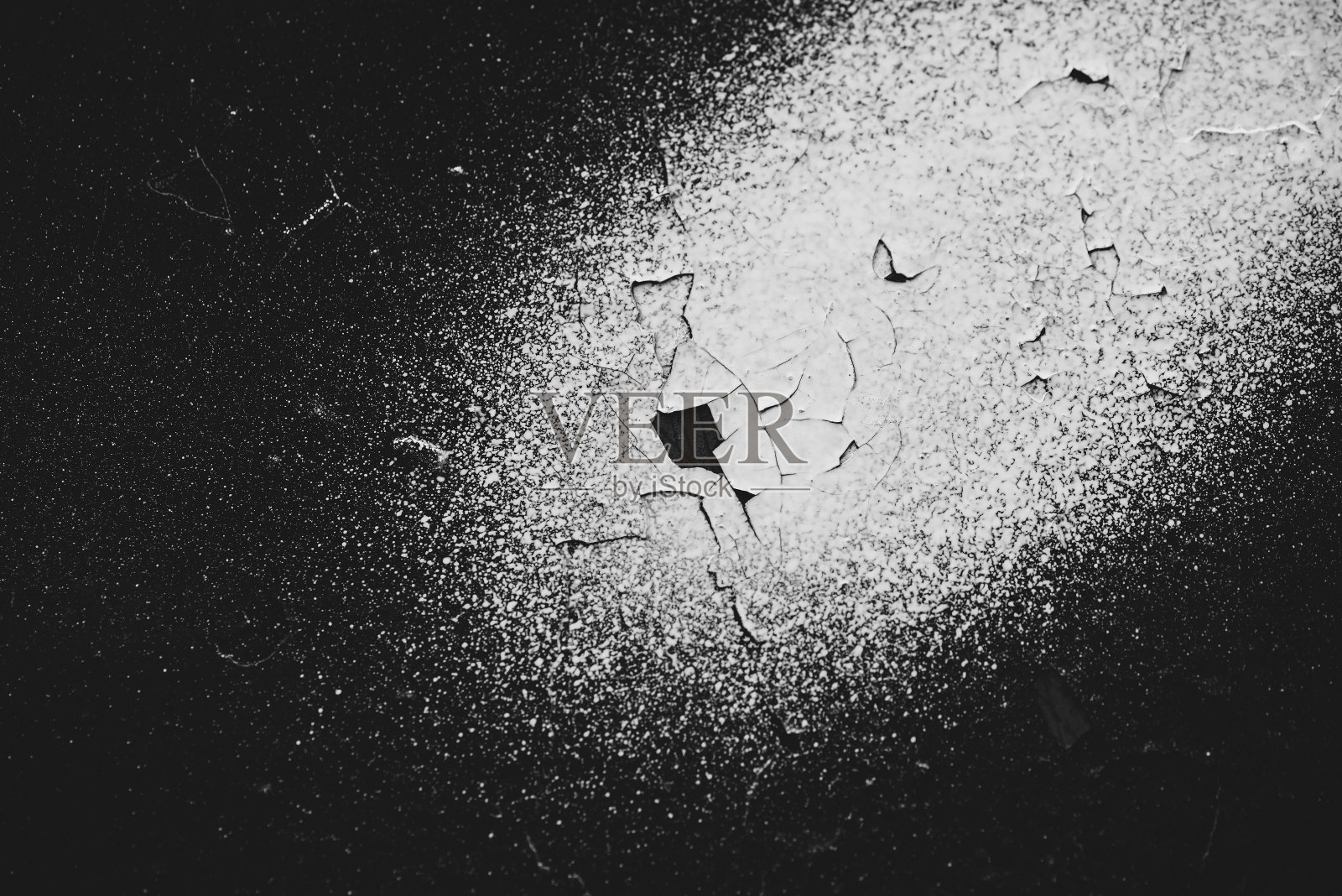 肮脏的黑色墙壁特写。单色背景与白色染料喷雾。黑色混凝土墙的黑白色纹理与白色斑点。以灰度绘制背景。油漆剥落了。剥落的灰泥。照片摄影图片