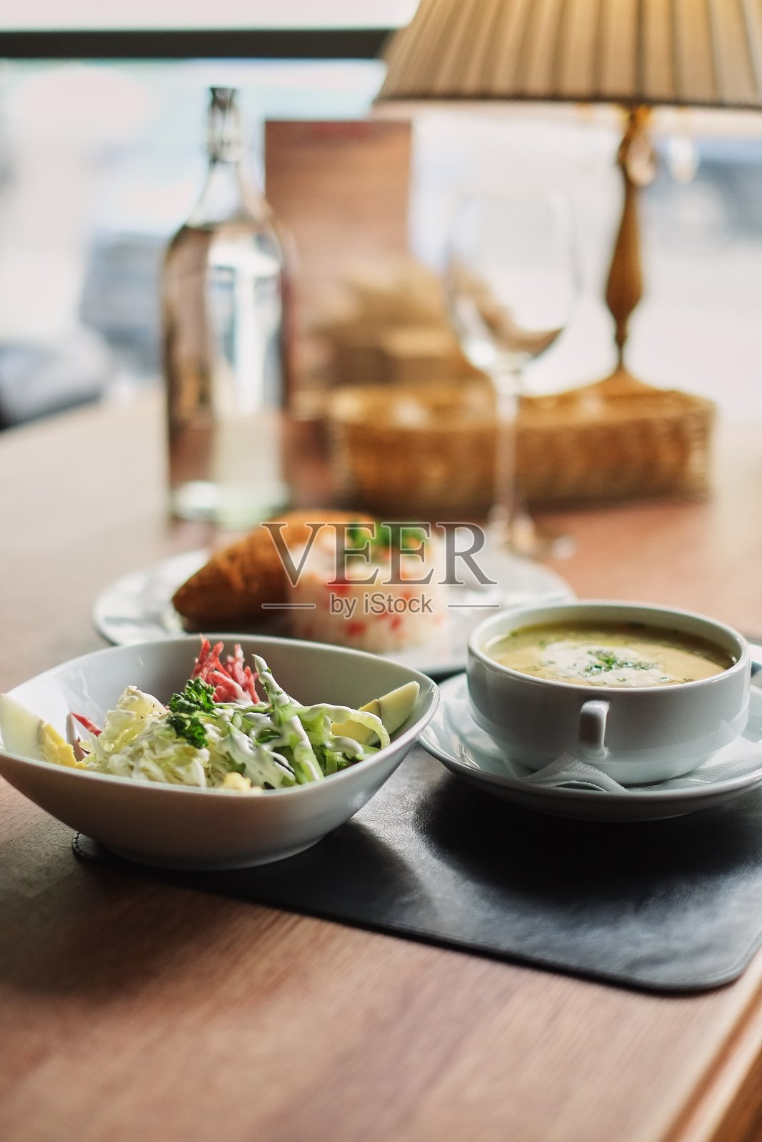 餐桌:一盘汤、意大利调味饭、肉排和蔬菜沙拉照片摄影图片