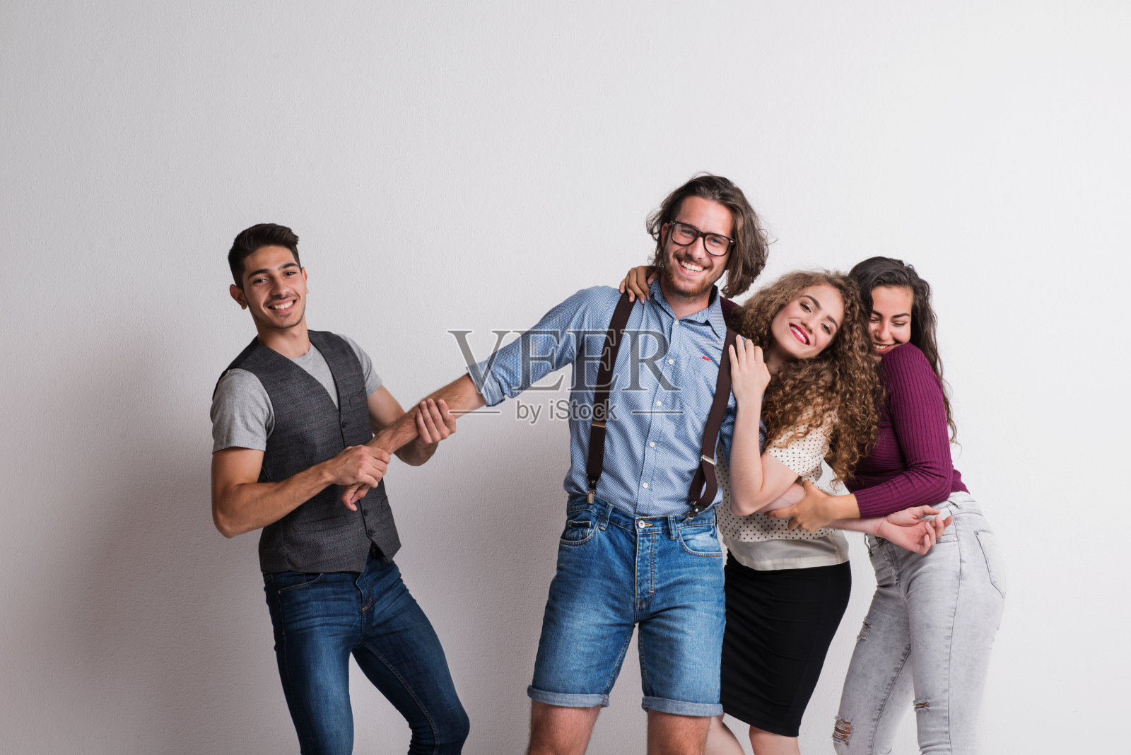 一群年轻的朋友站在工作室里，玩得很开心。照片摄影图片