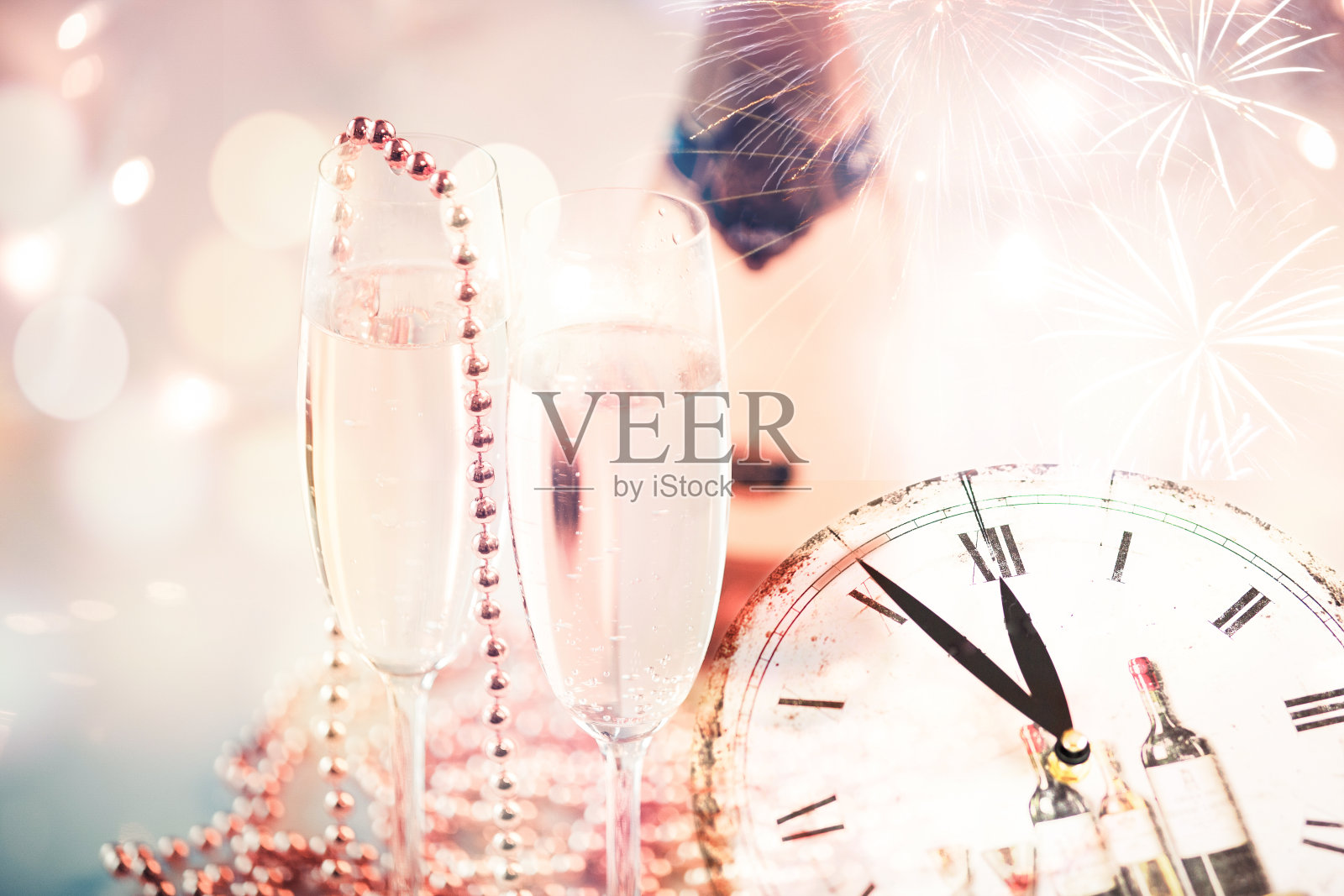 新年的香槟杯上放着烟花和时钟照片摄影图片