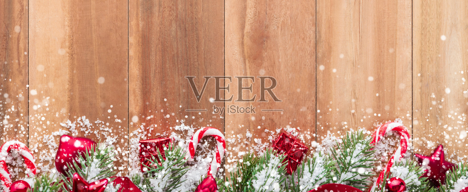 用雪装饰在木头背景上的圣诞装饰品照片摄影图片