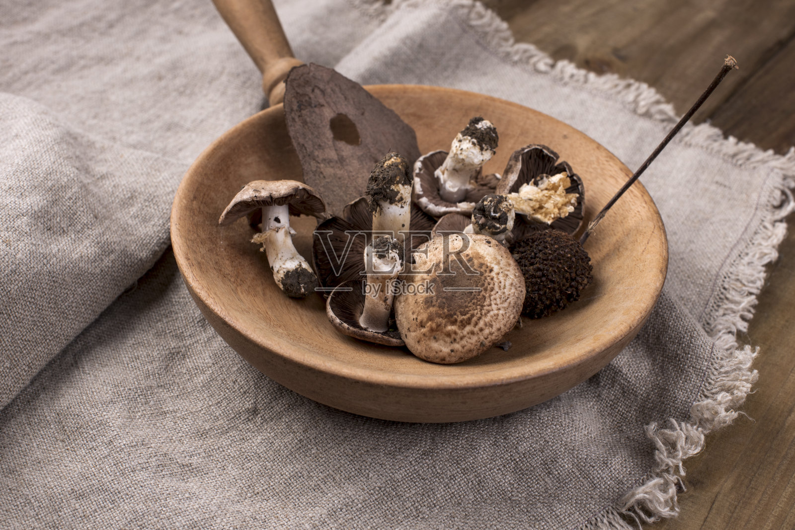 木色背景下平底锅里的蘑菇。复古照片和乡村风格的餐巾。自由空间的文本，俯视图。照片摄影图片