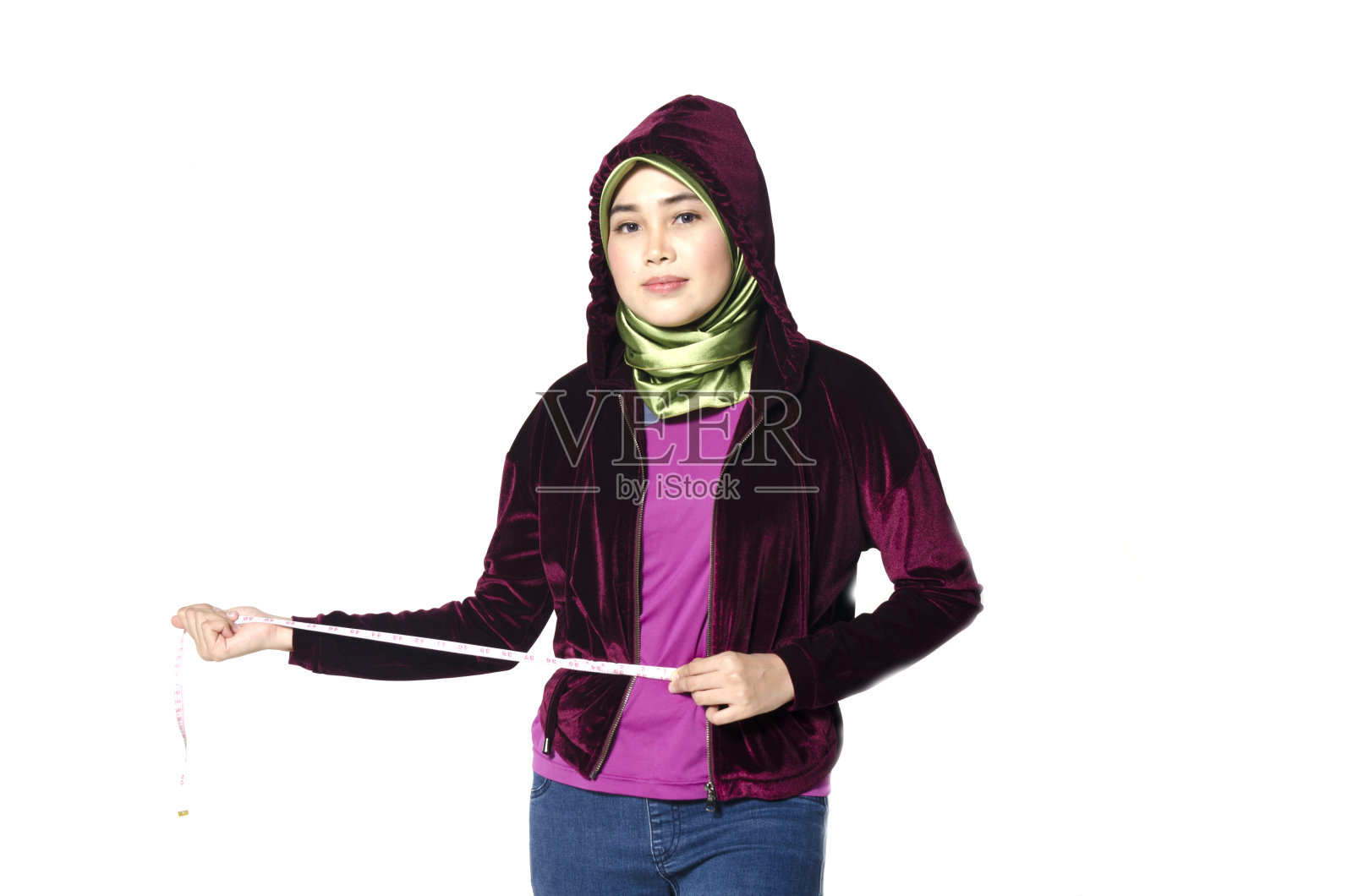 小女孩用卷尺测量自己的腰围，这对于减肥，苗条的身体和健康的生活方式来说是理想的照片摄影图片