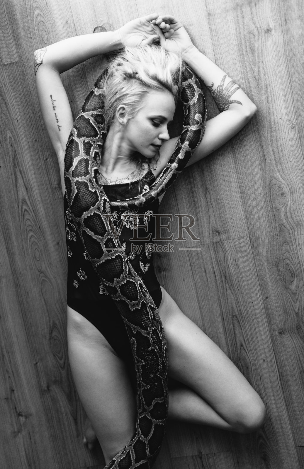 地板上有个女孩和一条蛇照片摄影图片