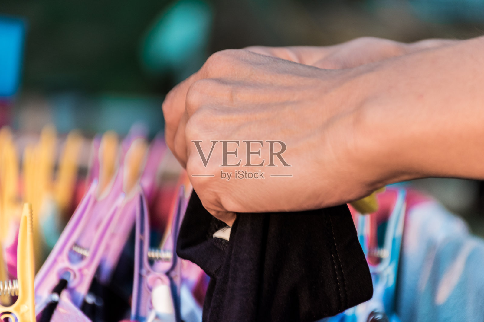 干净的衣服挂在衣架上，用彩色的衣夹别住照片摄影图片