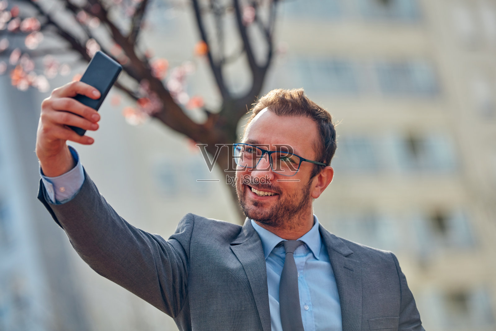 商人在街上用智能手机。照片摄影图片