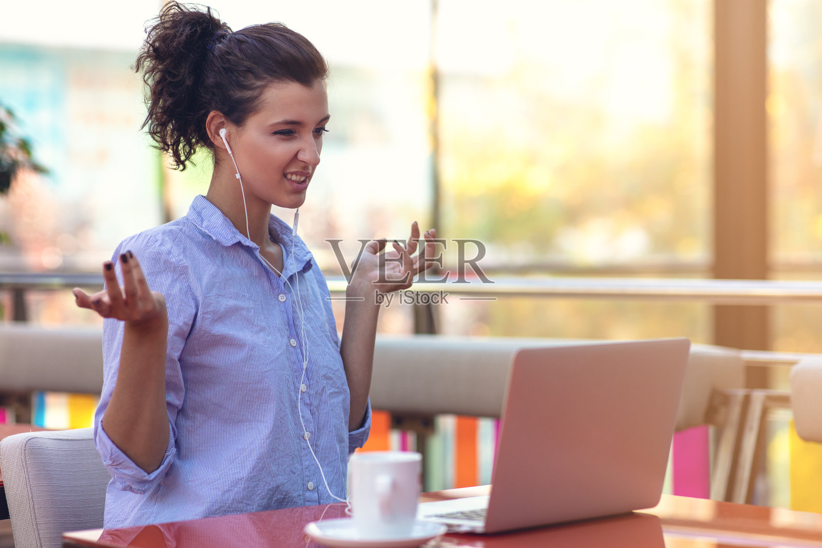 年轻迷人的混血女孩谁是微笑看着她的笔记本电脑屏幕在视频通话照片摄影图片