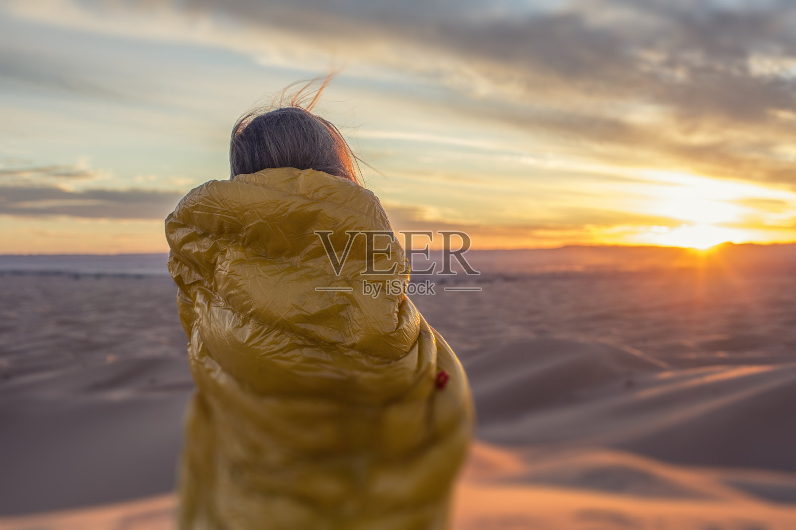 看着撒哈拉沙漠日落的女人照片摄影图片