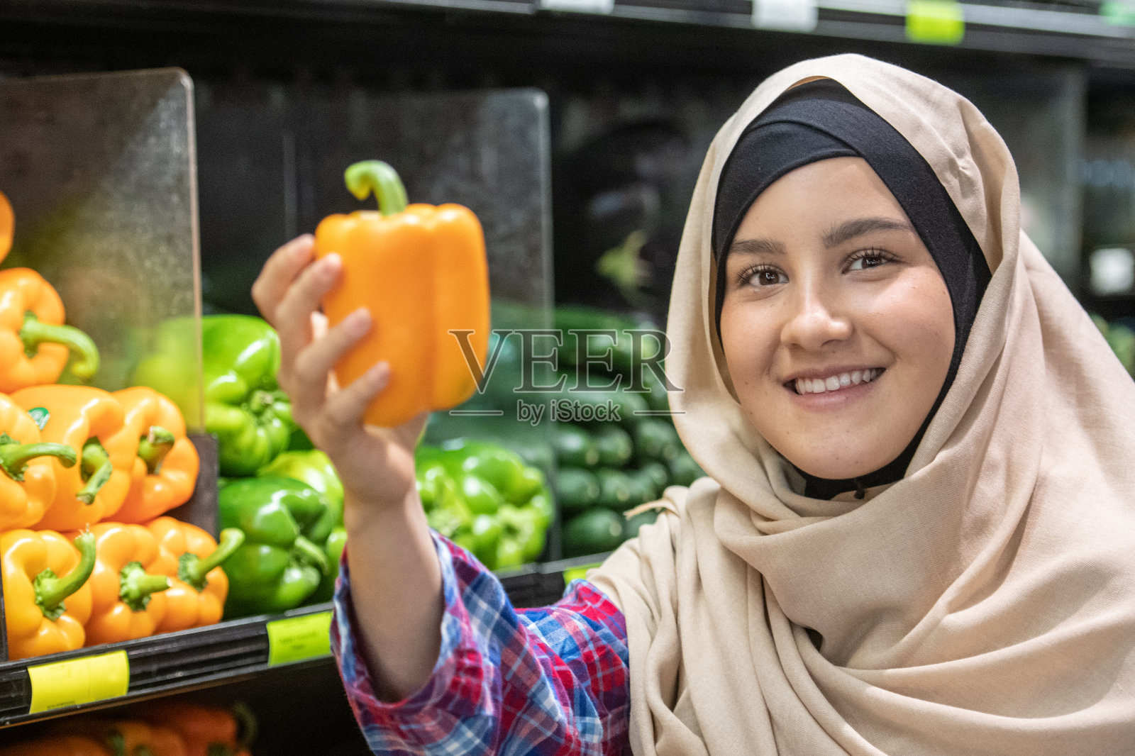 年轻的穆斯林妇女购买蔬菜照片摄影图片