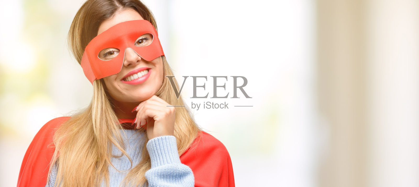 年轻的女超人一边思考一边仰望，表达着怀疑和疑惑照片摄影图片