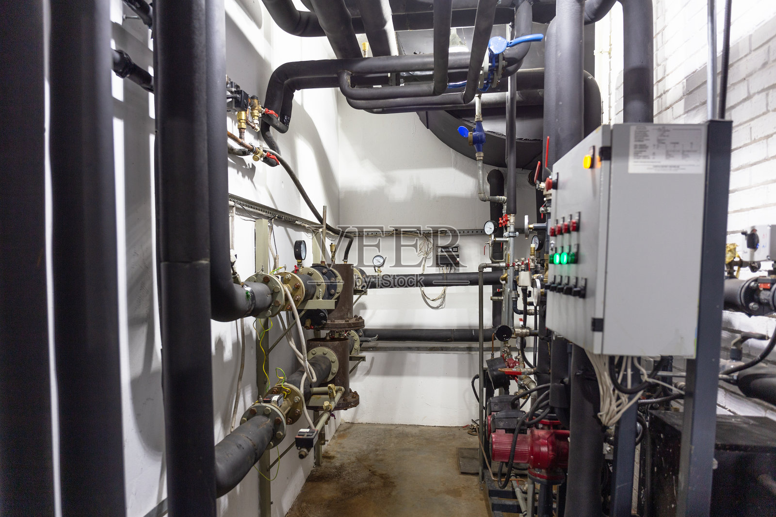 房屋供暖系统采用许多钢管、压力计和金属管以及自动化控制设备照片摄影图片