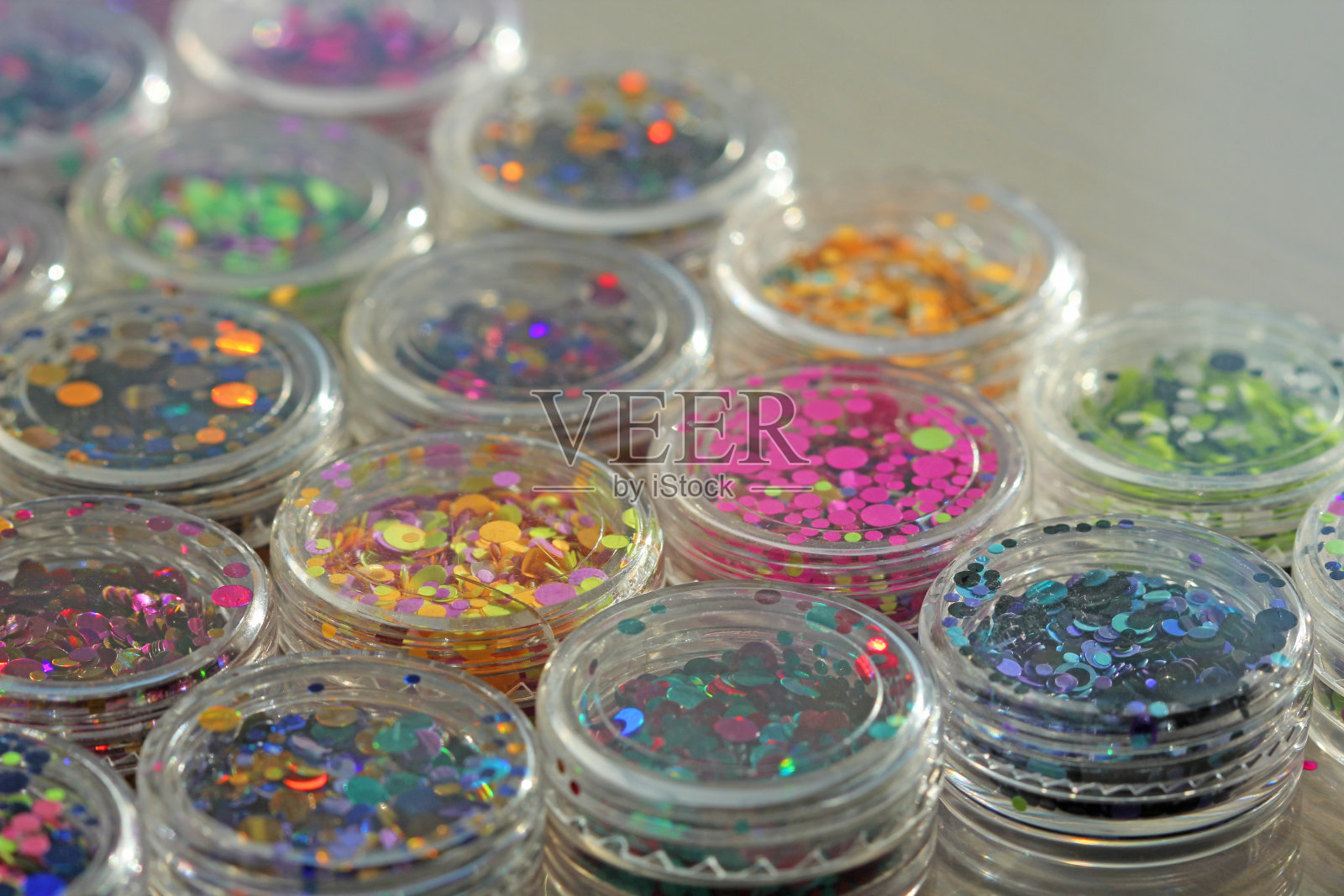多色亮片设计的钉子在一个罐子。在jar闪闪发光。指甲用锡箔。组照片。闪闪美丽，闪闪发光。明亮的背景闪光。俯视图照片摄影图片