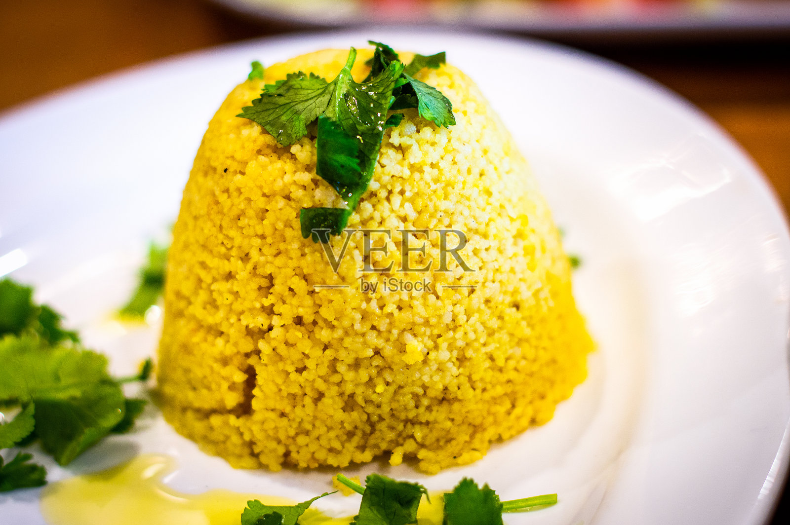 白盘子里的摩洛哥蒸粗麦粉配菜照片摄影图片