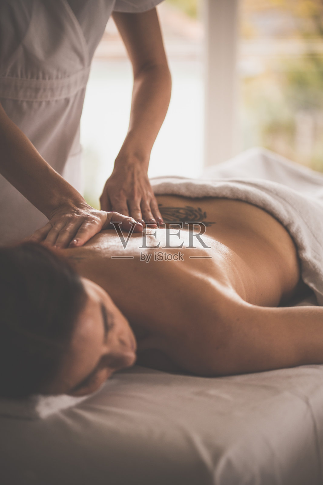 按摩师为病人做背部按摩照片摄影图片