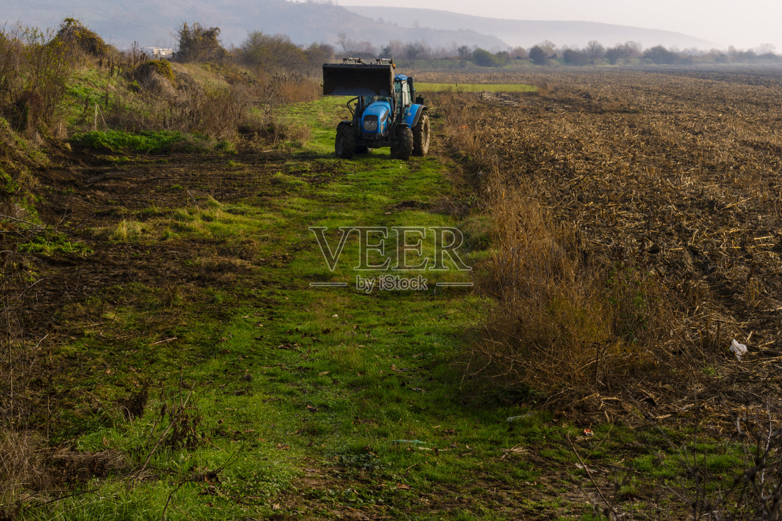 拖拉机在田里工作在去阿斯帕鲁霍沃村的路上。照片摄影图片