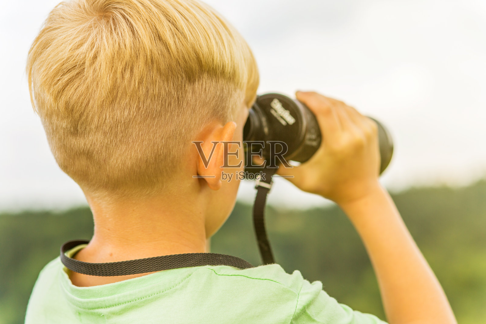 小男孩在户外用望远镜看东西照片摄影图片