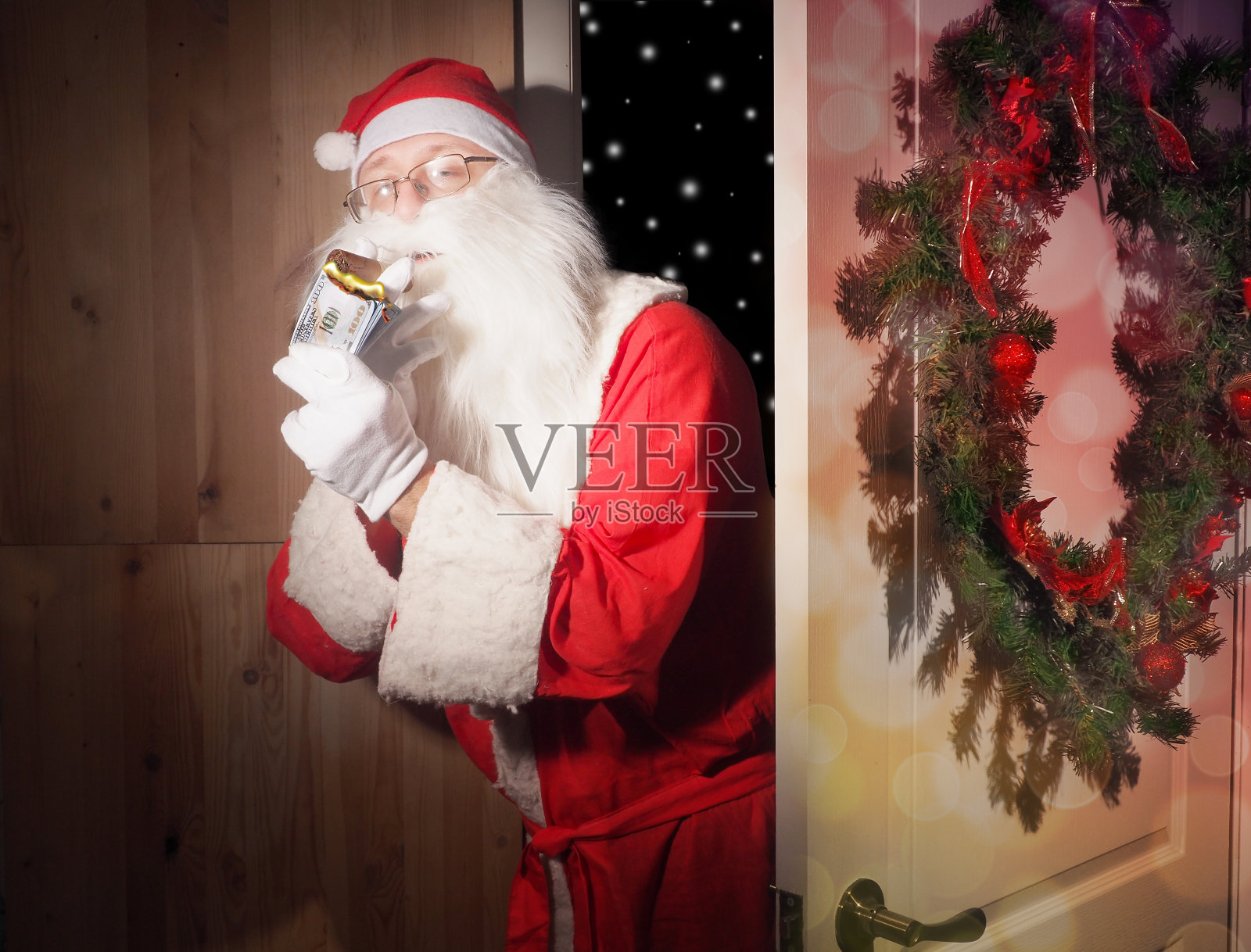 圣诞老人从一个下雪的夜晚打开了房间的门照片摄影图片