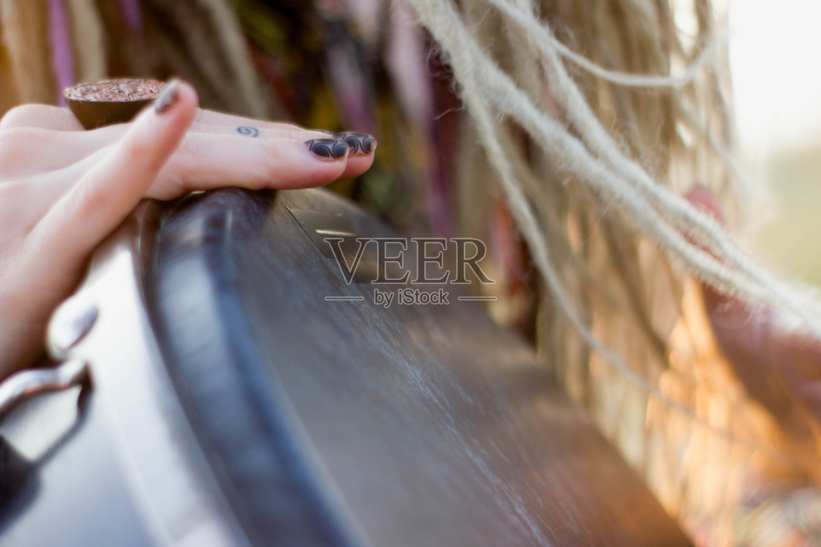 美丽的年轻女子嬉皮萨满演奏djembe和跳舞在日落照片摄影图片