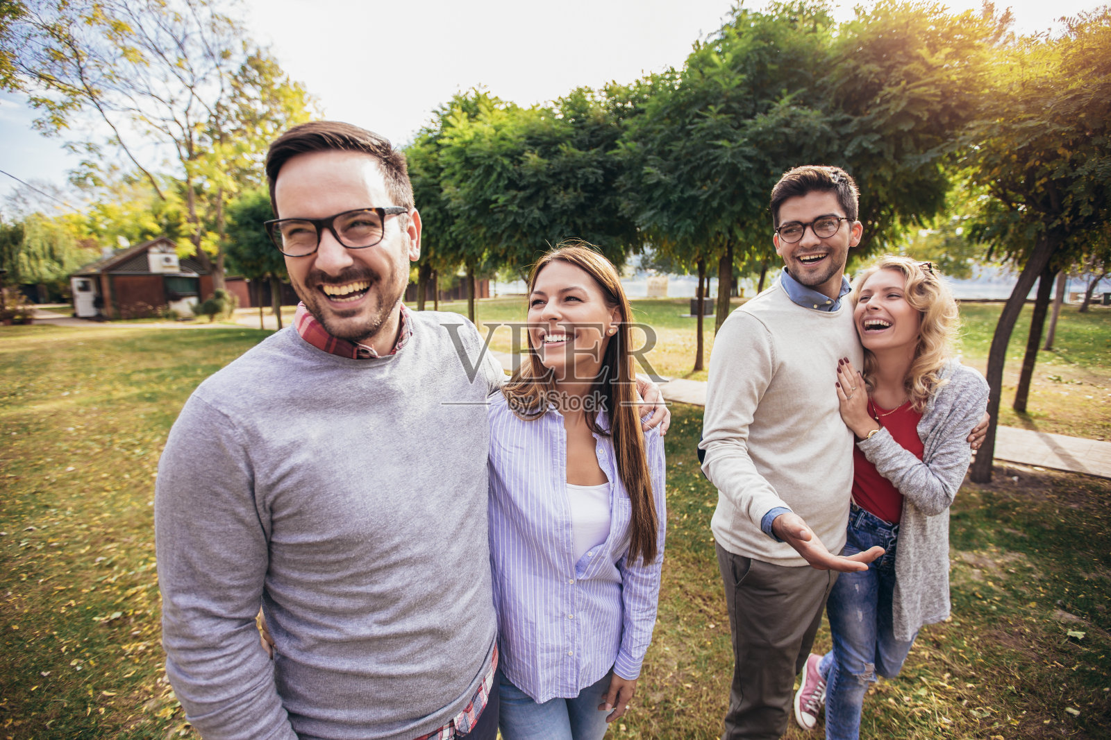 一群年轻人穿过公园。朋友们在户外玩照片摄影图片