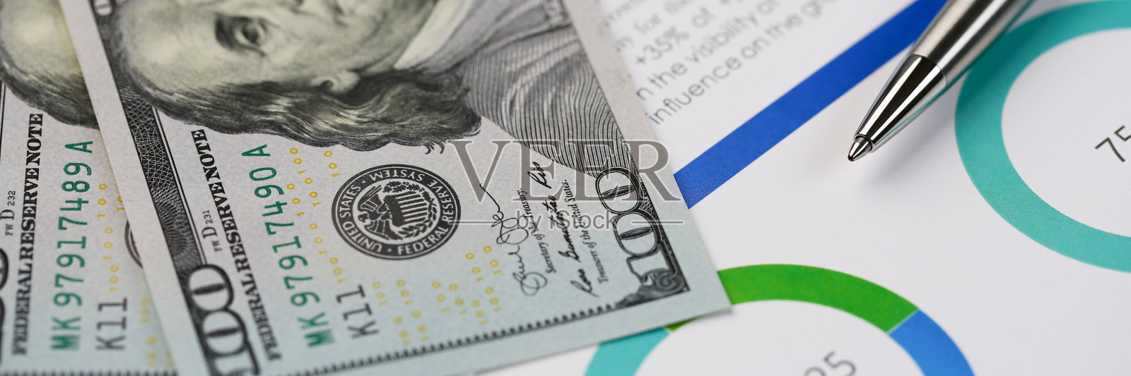 银笔躺在书桌上，积满现金照片摄影图片