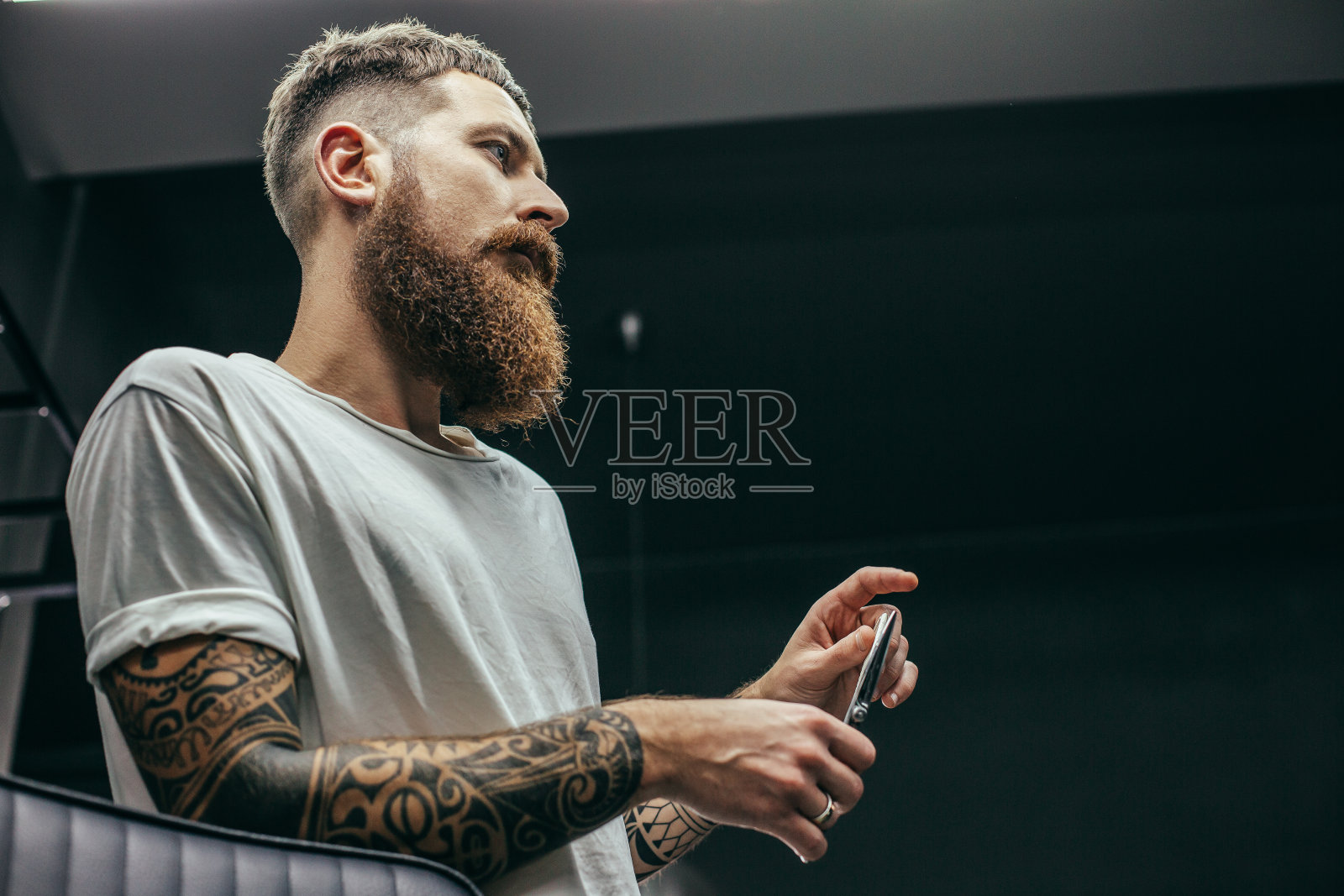 近距离的胡子理发师站着和拿着剪刀照片摄影图片