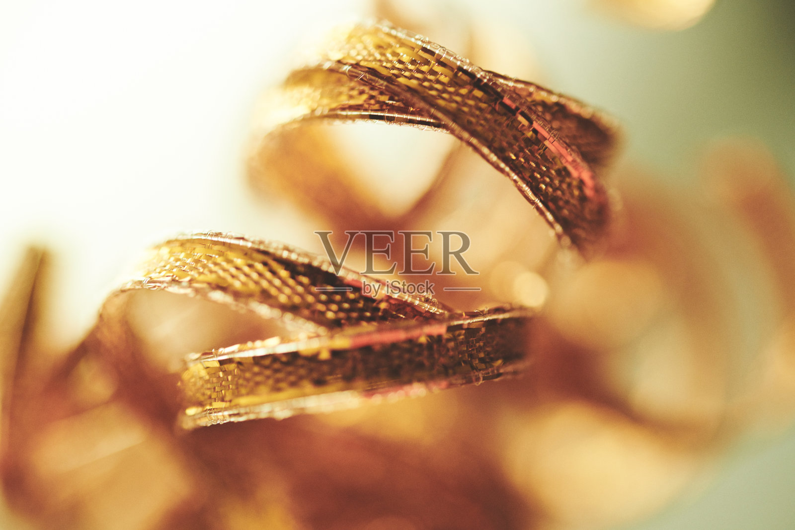 带蓝绿色背景的卷曲金色丝带照片摄影图片