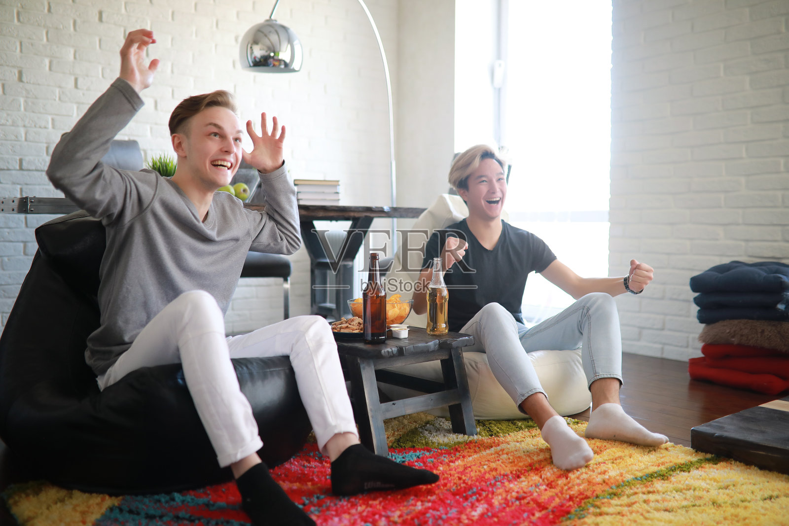 足球迷一边看比赛一边喝啤酒照片摄影图片