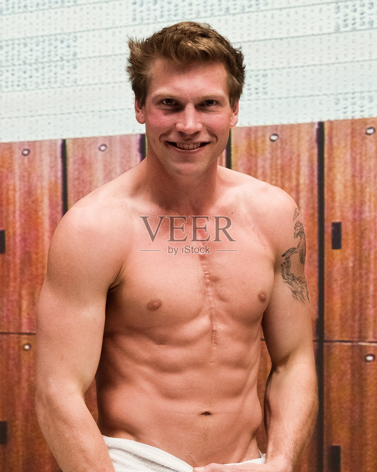 赤裸上身的男人在健身房的更衣室里照片摄影图片