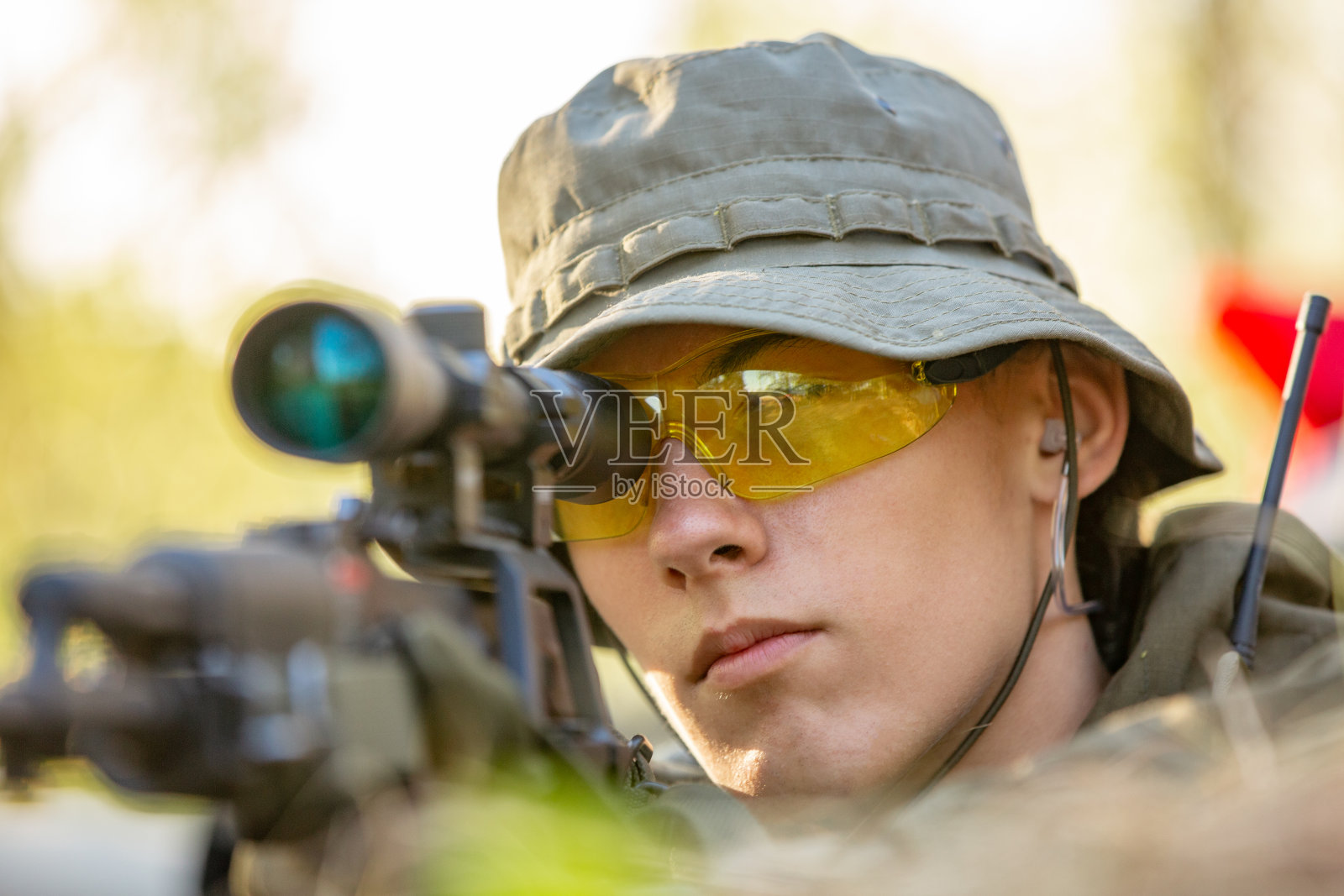 狙击手装备大口径狙击步枪，从掩蔽处、埋伏处向敌人射击照片摄影图片