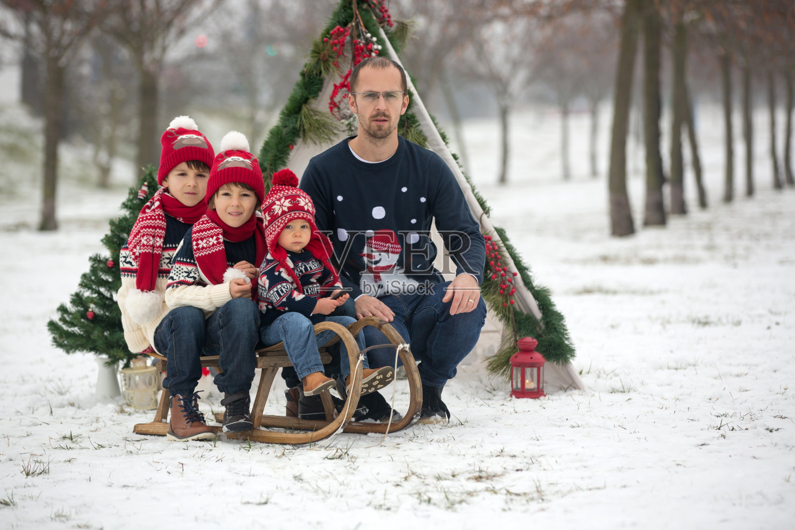 快乐的家庭和孩子们，在圣诞节在户外玩雪，玩雪橇照片摄影图片