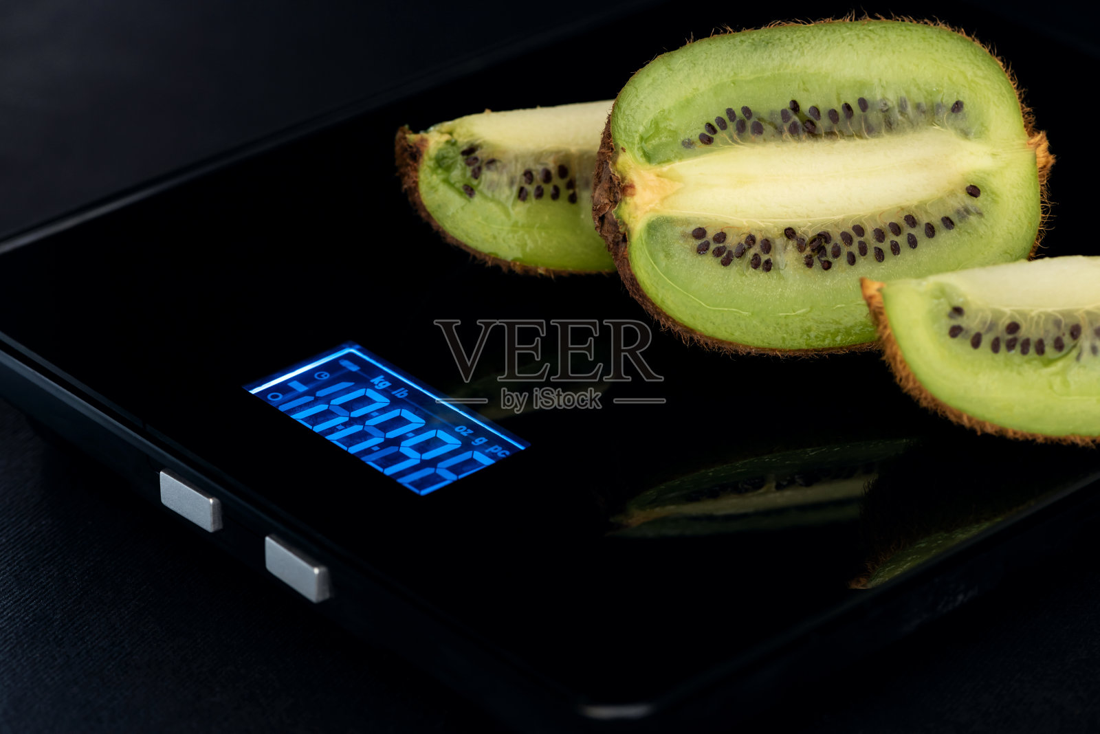 电子秤上切好的猕猴桃。照片摄影图片