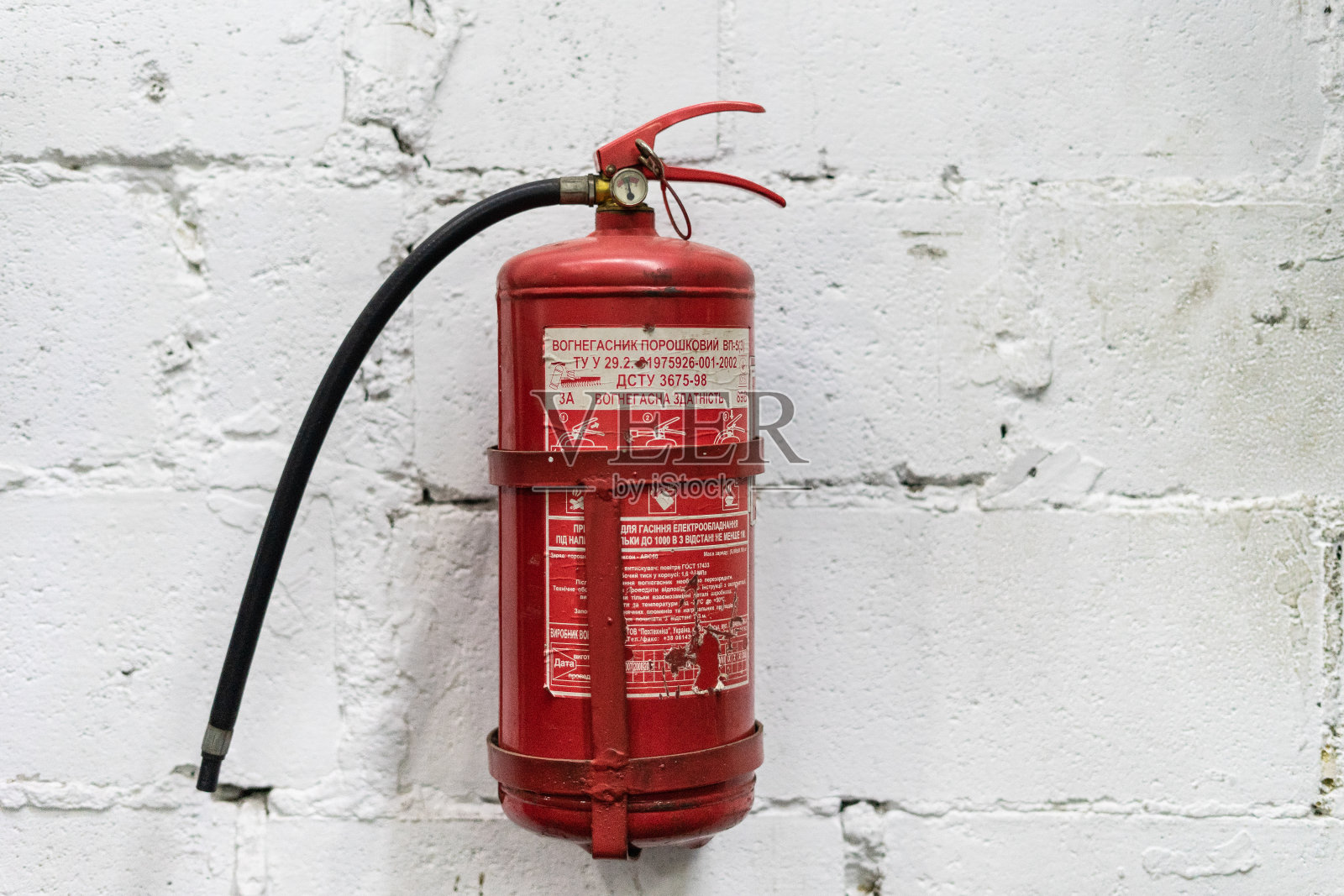 白色墙壁背景上装有红色灭火器，随时可用照片摄影图片