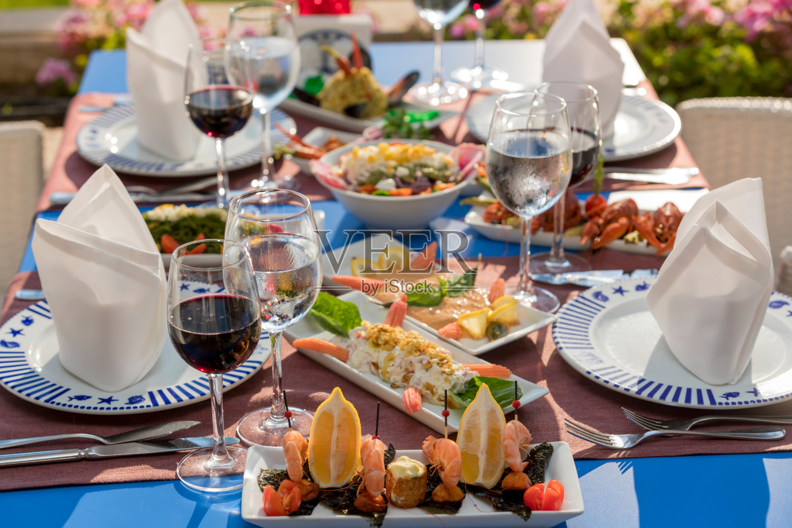 户外的午餐桌上摆满了各种海鲜和饮料照片摄影图片