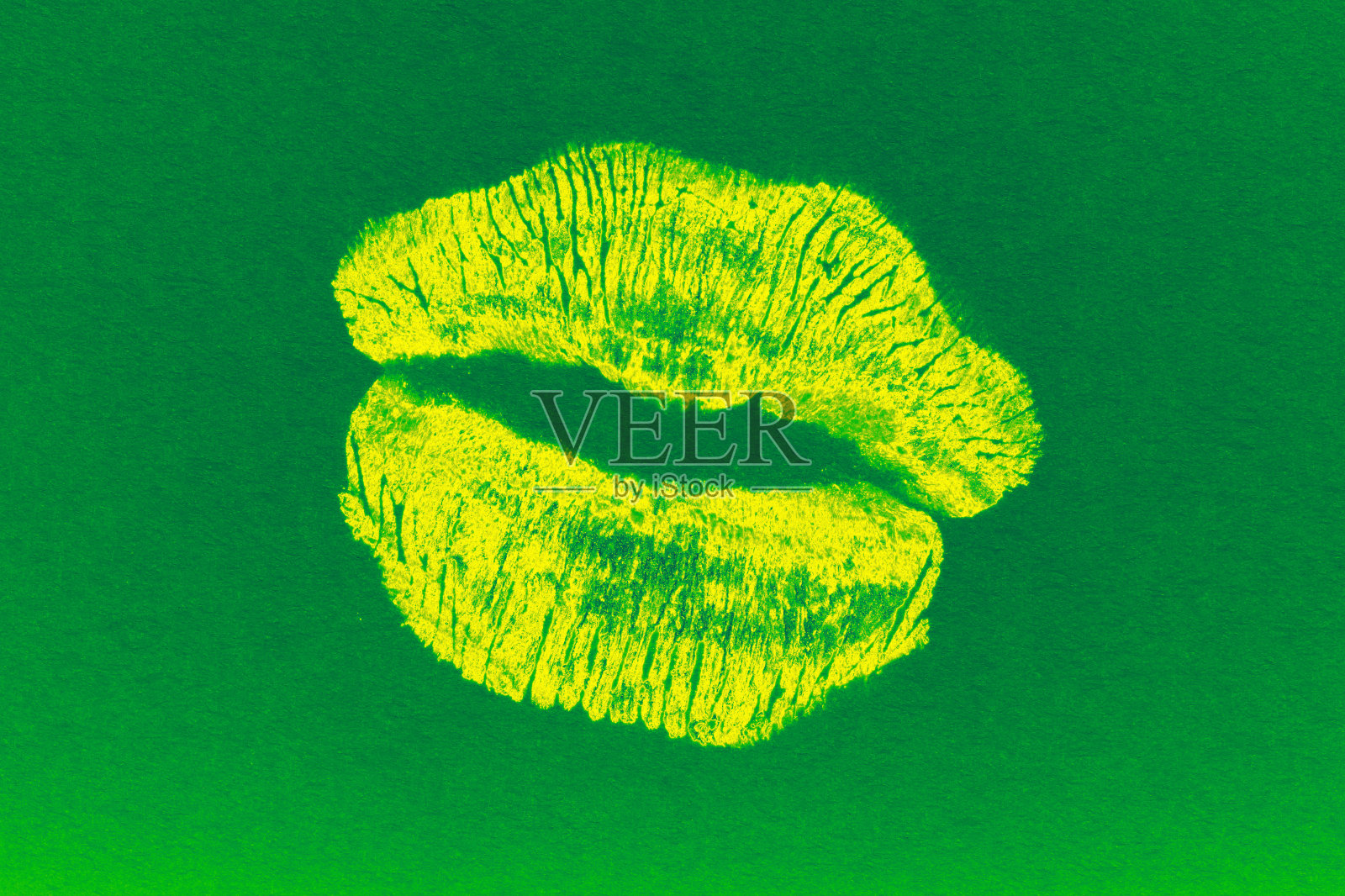 黄色的唇印印在绿色的纸上照片摄影图片