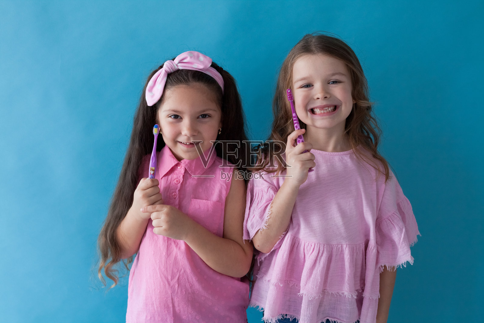 两个小女孩展示着牙刷和牙科照片摄影图片