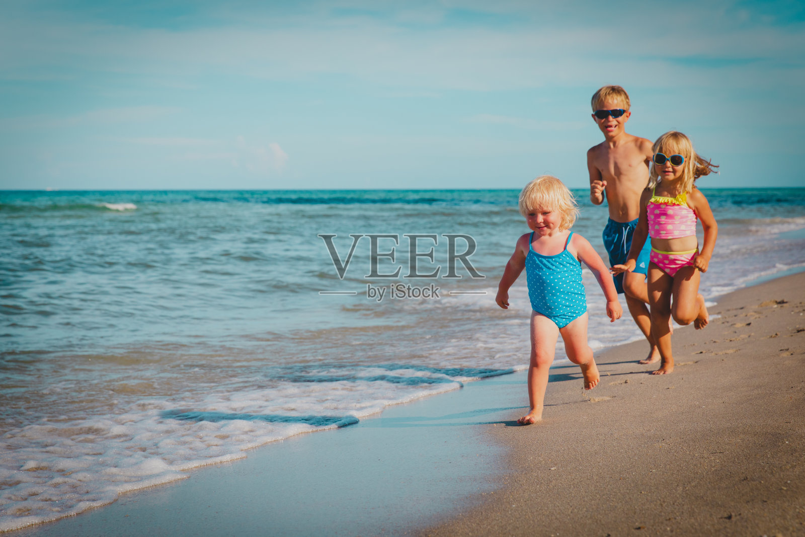 快乐的孩子们-小男孩和小女孩-在海滩上奔跑玩耍照片摄影图片