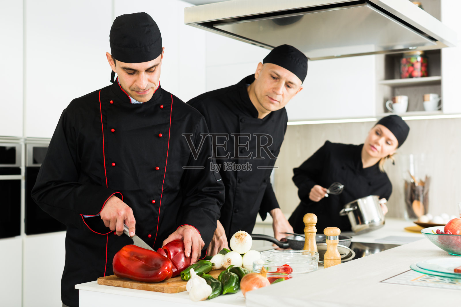 一名女厨师和两名男厨师正在厨房的工作场所做沙拉照片摄影图片