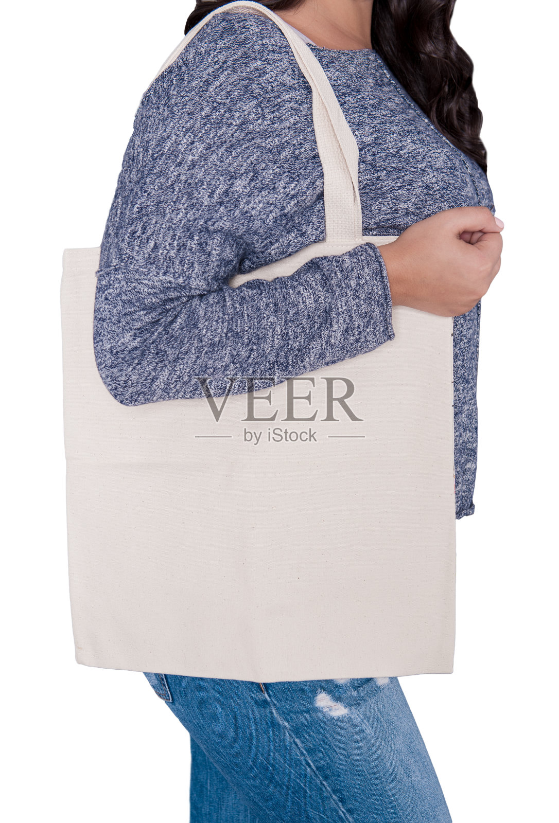 女人在牛仔裤拿着空白纺织袋隔离。模型设计照片摄影图片