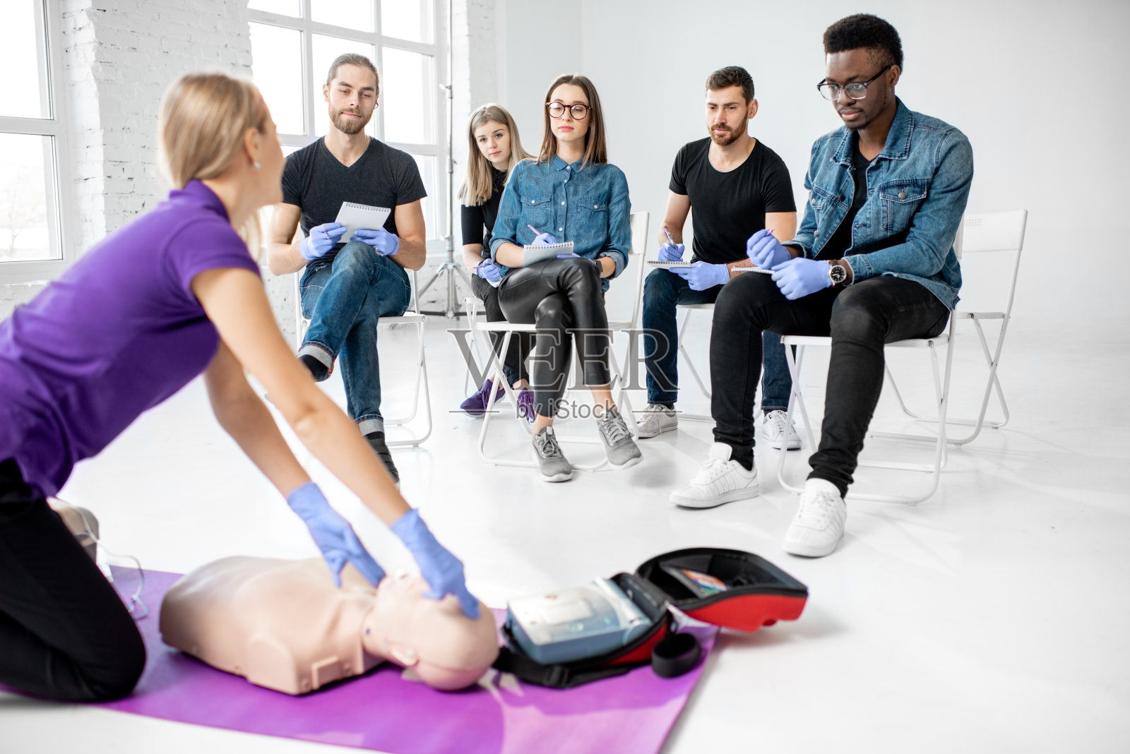 一群年轻人坐在现场接受急救培训照片摄影图片