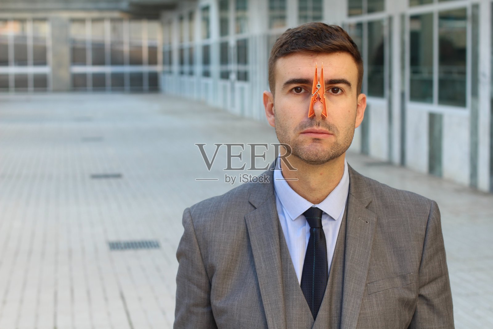 用衣夹夹住鼻子的商人照片摄影图片