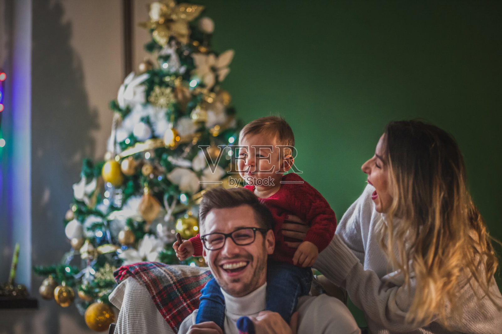 年轻的家庭在家里庆祝圣诞节照片摄影图片
