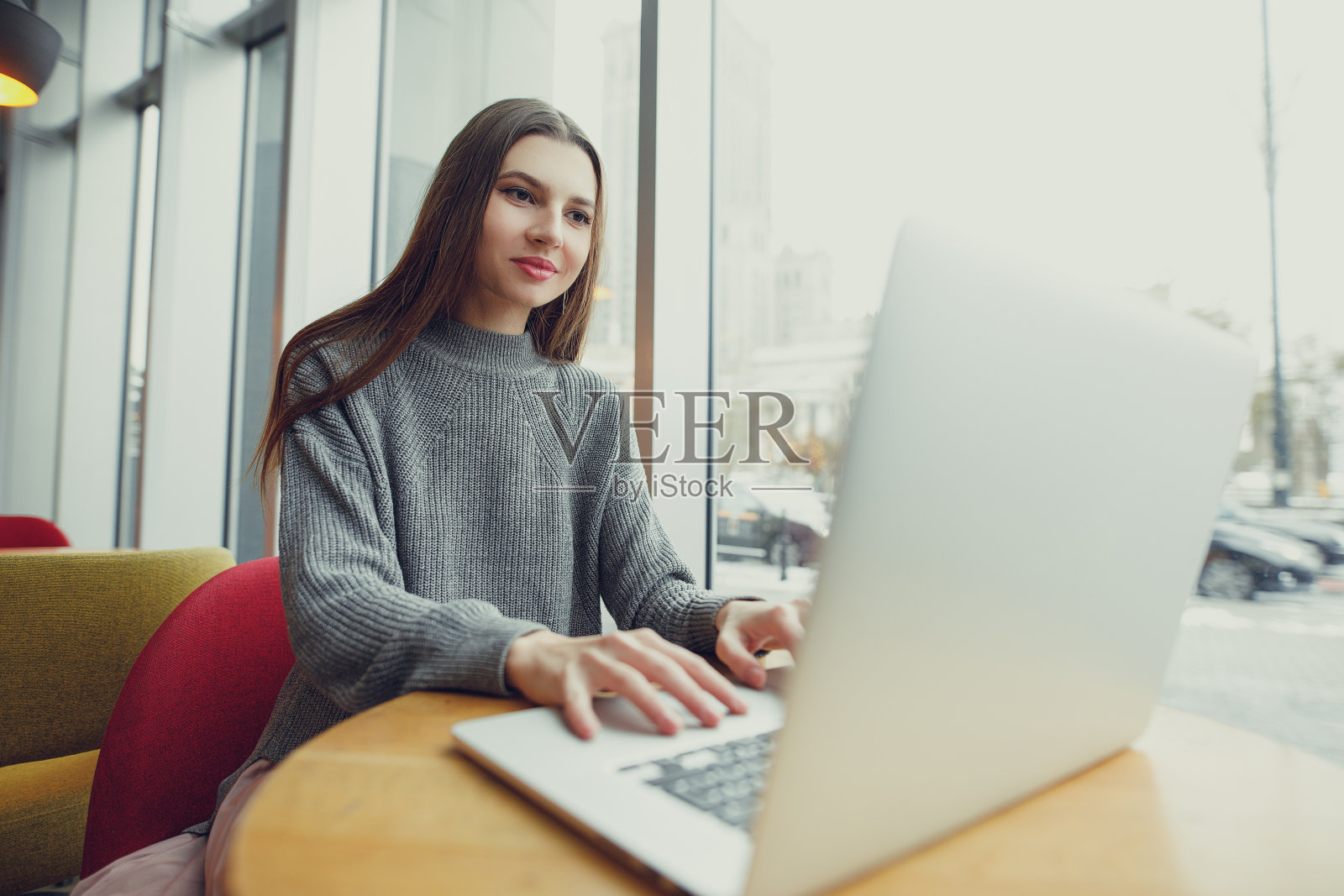 视图。年轻的女商人坐在桌子旁，在笔记本上记笔记。在咖啡馆工作的女人。博主。——图片照片摄影图片