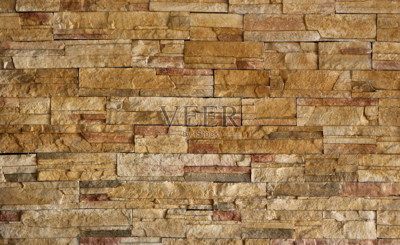 石材涂料墙由天然棕色岩石的条纹堆叠板制成。照片摄影图片