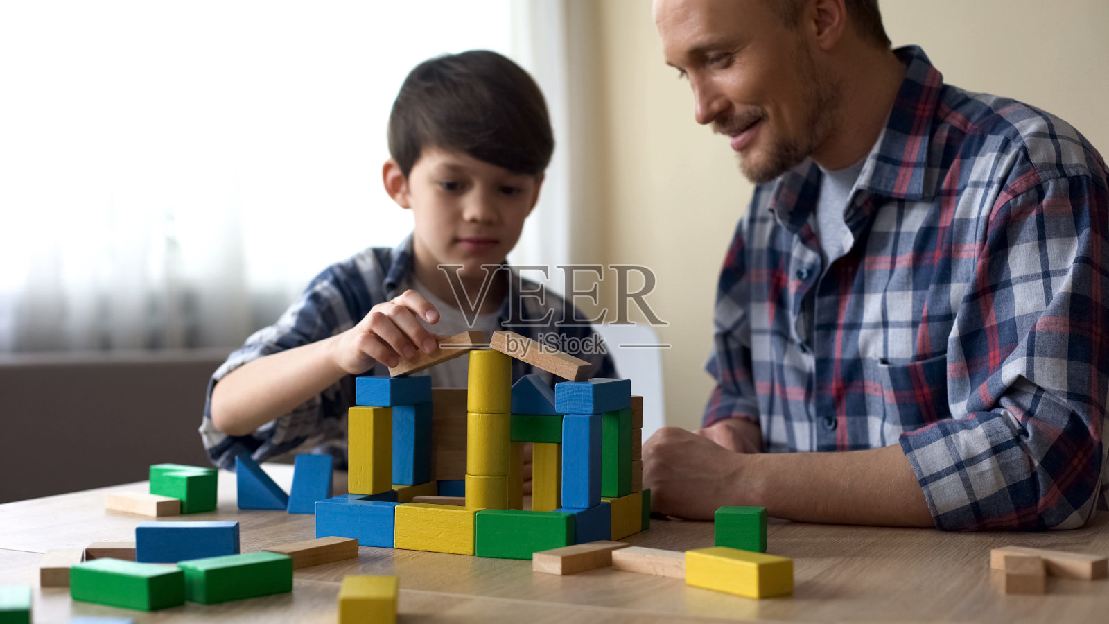 帅气的小男孩和爸爸在家里玩彩色方块玩具，童年照片摄影图片