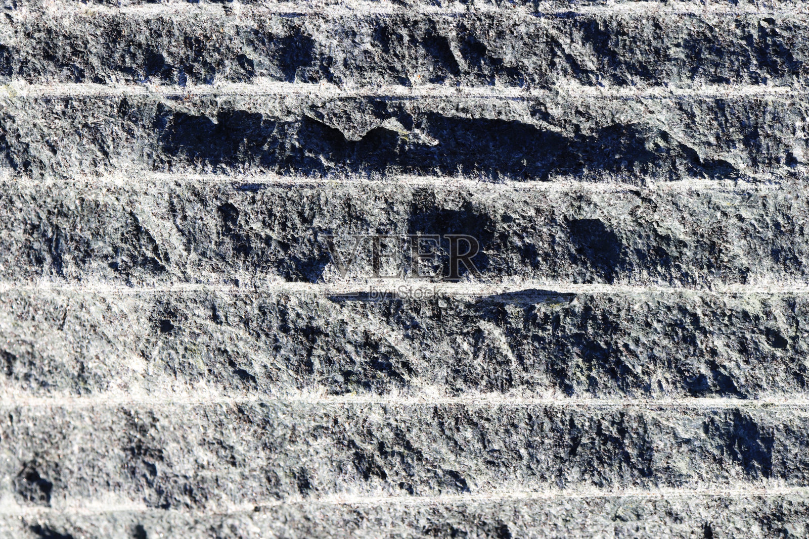 沿花岗岩剥落墙面纹理。花岗岩表面的背景。照片摄影图片