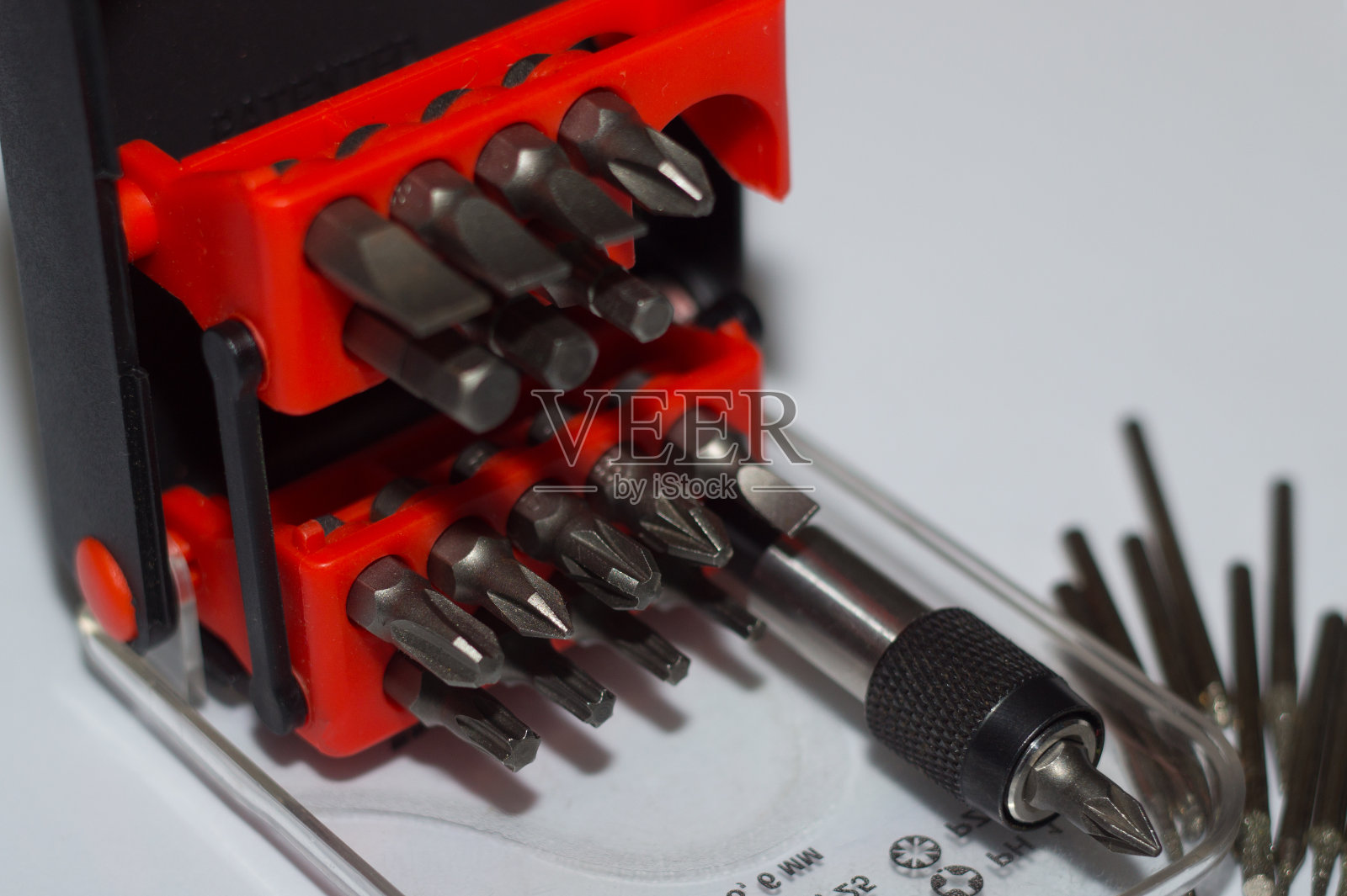 位holder在盒子和许多工具位在白色背景。特写镜头。塑料盒子里的红色元素。照片摄影图片