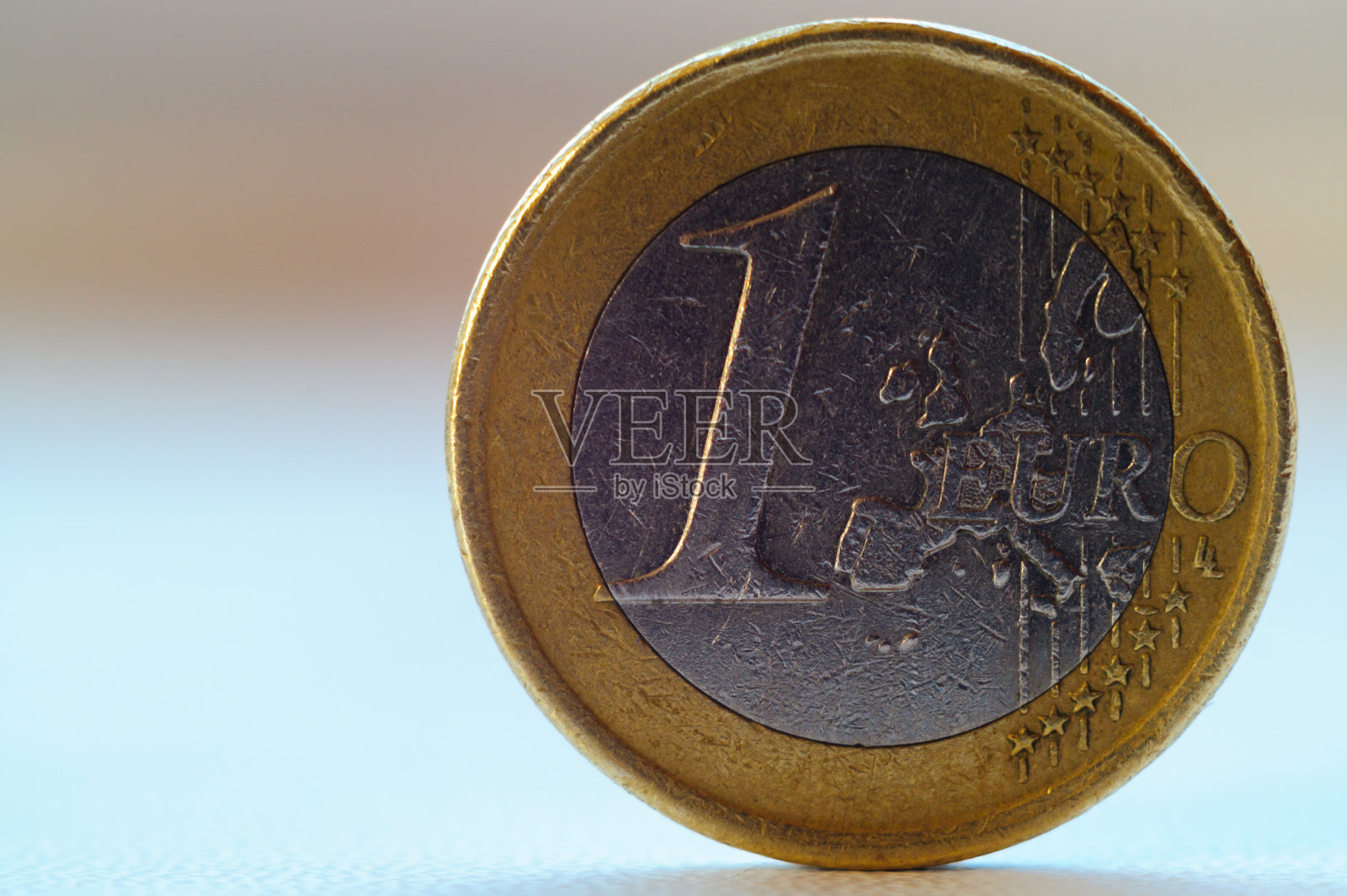 旧的1欧元硬币站在模糊的背景。照片摄影图片