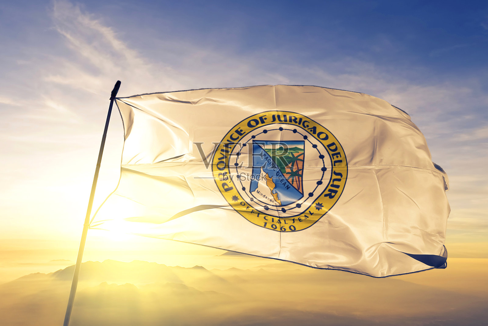 菲律宾苏里高省的国旗、纺织品、布料在日出的薄雾上飘扬照片摄影图片