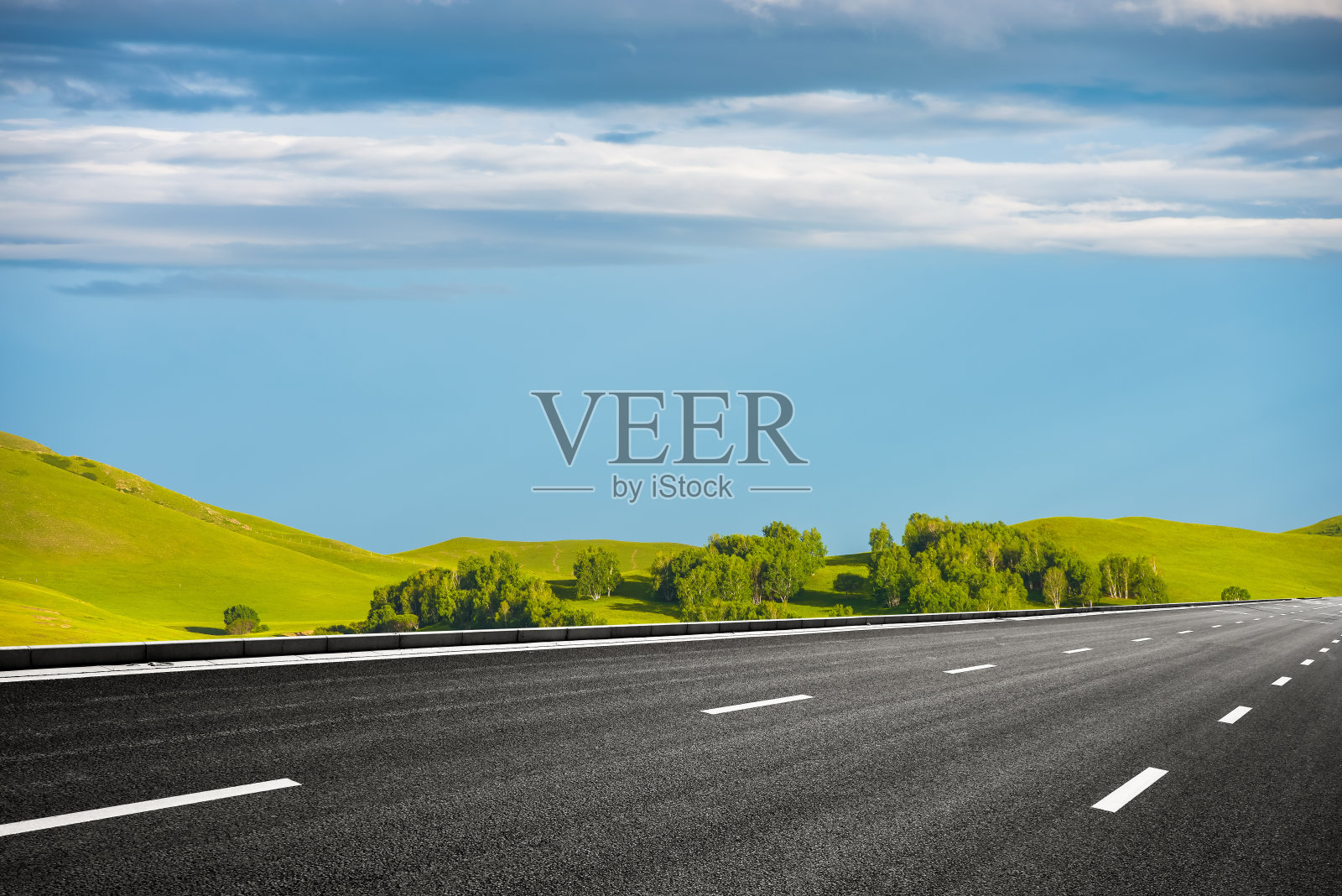 草原上森林边缘的高速公路照片摄影图片