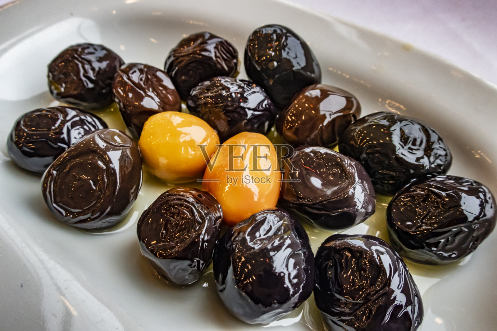 把黑色和绿色的橄榄放在盘子里作为早餐照片摄影图片